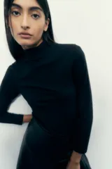 Polera negra de cuello alto y manga larga.