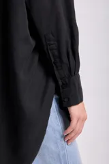 Camisa negra de lyocell con cuello clásico, cierre frontal con botones, manga larga y bolsillo en el pecho.