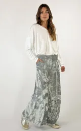 Pantalón palazzo de terciopelo color borgoña con textura arrugada y bolsillos laterales.