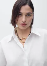 Camisa de manga corta con cuello camisero y cierre frontal de botones. Confeccionada en una mezcla de lino y algodón, presenta un diseño recto y minimalista.