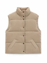 Chaleco acolchado de pana color marrón, con cuello alto, cierre frontal con botones a presión y bolsillos laterales.