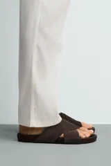 Sandalias de cuero con acabado de gamuza, color marrón, con dos tiras anchas cruzadas en el empeine y suela plana.