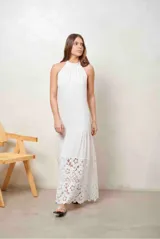 Vestido largo blanco de corte recto y sin mangas, con cuello halter y detalle de broderie en el borde inferior.