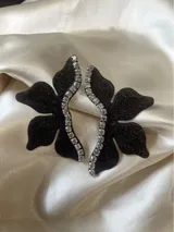 Par de aros dorados con forma de media flor, con detalle de strass negro y gancho de acero quirúrgico.