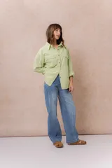 Jean de tiro medio con diseño de pierna amplia tipo wide leg, calce relajado y lavado celeste, con costuras frontales destacadas.