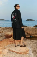 Bermuda negra de lino y rayón con elástico en la cintura, largo a media pantorrilla, tiro bajo y fit oversized en A.