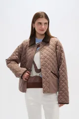 Campera marrón con diseño acolchado, cuello de pana marrón, cierre con botones a presión y bolsillos laterales.