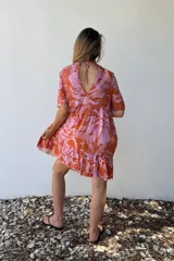 Vestido corto con volados, estampado con hojas en tonos rosa y naranja, de corte suelto y mangas cortas.