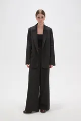 Blazer de corte holgado con diseño de rayas verticales, cuello solapa y cierre frontal con un botón. Cuenta con bolsillos laterales con solapa.