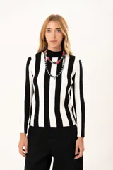 Polera de tejido de punto con diseño de rayas verticales anchas en blanco y negro, cuello alto y manga larga.