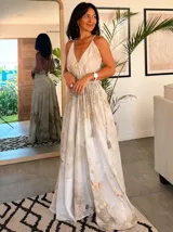 Vestido largo sin mangas con escote en V pronunciado, de corte amplio y fluido, con estampado abstracto en tonos rosados, marrones y blancos, y un cordón trenzado ajustable en la cintura.