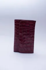 Billetera negra de cuero con textura tipo cocodrilo, con múltiples ranuras para tarjetas y billetes.