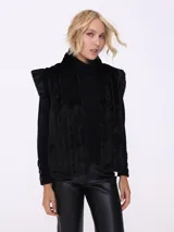 Chaleco de piel sintética color crema con diseño trenzado y bolsillos laterales.