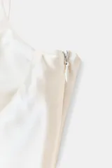 Top de breteles finos confeccionado en tejido satinado color rosa claro, con escote corazón y cierre lateral con cremallera oculta.