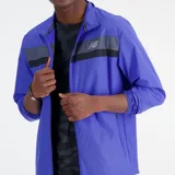 Campera de running New Balance Accelerate Jacket para hombre, color azul con franja horizontal gris y negra en el pecho y logo de la marca en gris.