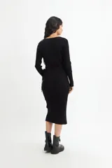 Vestido midi color crema, tejido en punto acanalado, con escote cruzado en V, mangas largas y lazo ajustable en la cintura.