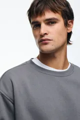 Buzo de tejido de mezcla de algodón de peso medio con interior cepillado suave. Modelo con cuello redondo ribeteado, hombros caídos y remate acanalado ancho en puños y bajo. Corte holgado.