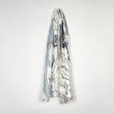 Pashmina de textura suave con estampado abstracto que simula vetas de mármol en tonos blanco, gris y azul.