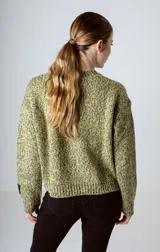 Sweater de tejido de punto con textura jaspeada en tonos verdes y amarillos, de corte holgado, cuello redondo y manga larga con detalle de etiqueta en el puño.