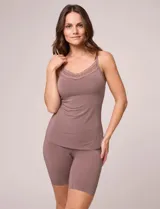 Musculosa de lencería color blanco, con escote redondo adornado con detalle de puntilla y tirantes finos regulables. Confeccionada en tejido seamless de alta elasticidad para un ajuste ergonómico y acabado invisible.