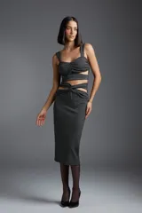 Top negro con estampado de lunares blancos, breteles anchos y detalle de flor blanca en el centro.