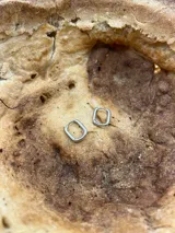 Par de aros plateados con forma de argolla rectangular.