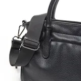 Cartera chica de símil cuero color negro, de diseño estructurado con doble asa de mano y correa de hombro ajustable y desmontable. Cuenta con detalles de cordones fruncidos en los laterales y el logo metálico de la marca en la parte frontal.