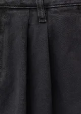 Pantalón de jean estilo wideleg color negro, con tiro medio, cierre frontal de cremallera y botón, trabillas para cinturón, bolsillos laterales y detalle de pinzas delanteras.