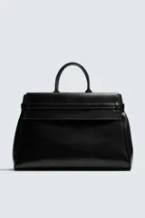 Bolso de mano de gran tamaño en color negro, con diseño estructurado, doble asa superior y cierre magnético. Incluye detalles de cintas laterales y compartimentos internos con cierre.