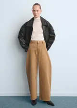 Jeans de corte wide leg y tiro medio en color tostado, con diseño de perneras abuchonadas y bolsillos delanteros simulados.