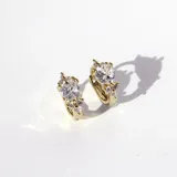 Par de aros tipo argolla dorados con bisagra, con un cristal en forma de corazón y pequeños cristales alrededor.