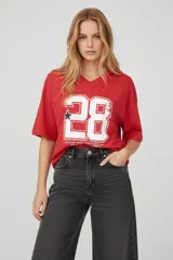 Remera de algodón color rojo con cuello en V y estampado frontal de números deportivos en blanco.