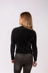 Sweater de textura suave y afelpada, color negro, con cuello redondo y mangas largas ajustadas.
