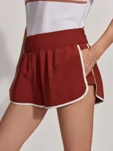 Short deportivo color ladrillo con ribete blanco, de corte clásico inspirado en la ropa deportiva.