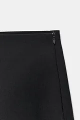 Falda pantalón mini de tiro medio color negro, con diseño estructurado y cierre lateral con cremallera oculta.