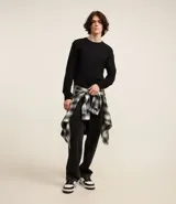 Remera de manga larga con cuello redondo, confeccionada en algodón. Presenta un corte comfort holgado y una pequeña etiqueta decorativa en el bajo.