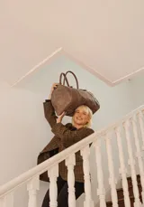 Bolso de mano tipo shopper marca Amadea, confeccionado en cuero con acabado desgastado. Presenta detalles de costuras decorativas verticales, correas con hebillas metálicas doradas y logo grabado al frente.