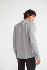 Remera de manga larga color gris melange, con cuello redondo y estampado gráfico en blanco y negro de la ciudad de Nueva York en el frente.