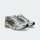 Championes Asics Gel Kayano 14 en color plateado con detalles en negro y dorado, de estilo retro inspirados en los años 2000, con capellada de malla y material sintético, y tecnología GEL en la suela.