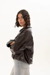 Campera de cuero sintético color chocolate, con cierre frontal, cuello camisero y diseño holgado.