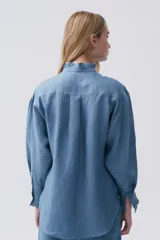 Camisa blanca de lino con cuello mao con volados, mangas largas y calce relajado.