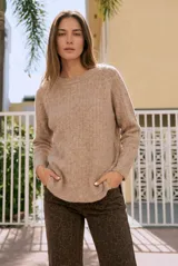 Sweater de punto con textura acanalada, cuello redondo y mangas largas. Presenta un diseño de calce holgado con ruedo redondeado y aberturas laterales.