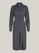 Vestido camisero midi azul marino con estampado geométrico en blanco, cuello camisero, manga larga con puños abotonados, cierre frontal con botones, cinturón de lazo y bajo asimétrico.