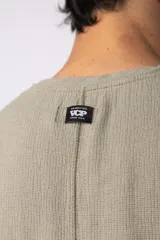 Musculosa oversize de tejido de lino con textura marcada, corte suelto, cuello redondo y terminaciones deshilachadas en las sisas.