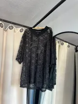 Remerón de encaje negro con diseño de cuello en V y mangas cortas. Presenta un estampado frontal bordado con texto y el número 32.