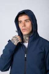 Campera de abrigo color azul, con cierre frontal, capucha ajustable y bolsillos laterales con cierre. Presenta un diseño minimalista con detalle de logo circular en la manga.