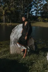 Pollera midi negra con detalle de cuero calado y flecos blancos en el ruedo.