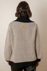 Campera de punto en lambswool, con diseño bicolor en beige y negro. Presenta cuello polo, cierre frontal con doble cursor, mangas largas con puños ajustados y bolsillos laterales.