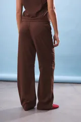 Pantalón de tiro alto color marrón oscuro, con cintura elástica ajustable mediante cordón y pierna ancha con caída.