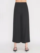 Pantalón palazzo de lino y viscosa, color blanco, de tiro alto y silueta amplia. Presenta pinzas frontales, bolsillos laterales y cierre con botón.